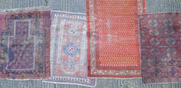 Four small red ground rugs. The largest 168 x 109 cm.