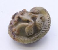 A carved jade model of a fruit and a snake. 3.5 cm wide.