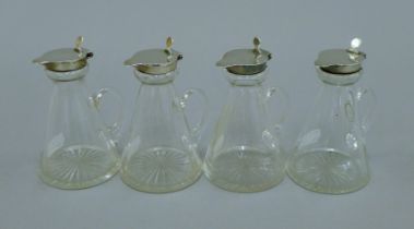 A set of four silver lidded glass toddy jugs. 10.5 cm high.