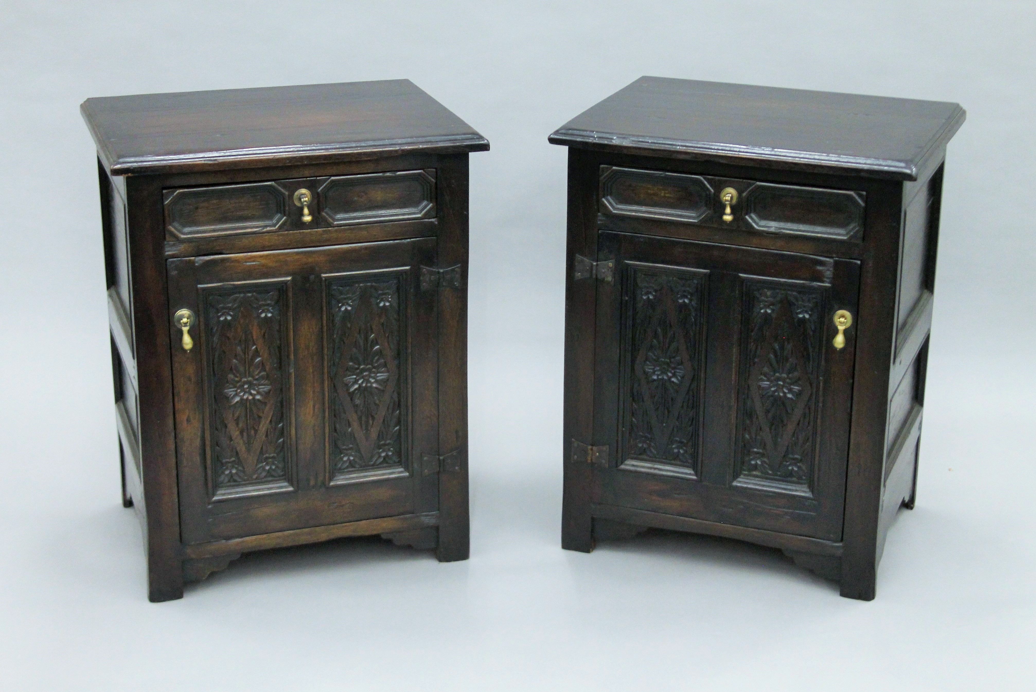 A pair of carved oak bedside cupboards. Each 53 cm wide.