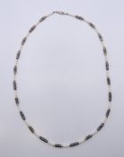 A silver and gold section pearl necklace. 72 cm long.