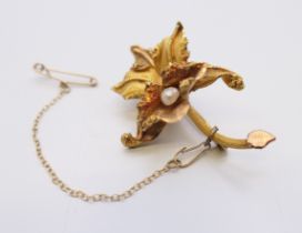 An 18 ct gold naturalist orchid brooch set with single pearl. 4.25 cm long. 9 grammes total weight.