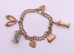 A 9 ct gold charm bracelet. 18 cm long. 26.5 grammes total weight.
