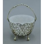 A silver pierced basket with milk glass liner. 12.5 cm wide. 187.3 grammes of silver.
