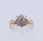 An 18 ct gold and platinum diamond cluster ring. Ring size M. 2.5 grammes total weight.