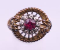 An unmarked gold ruby and diamond cluster ring. Ring size O. 6.1 grammes total weight.