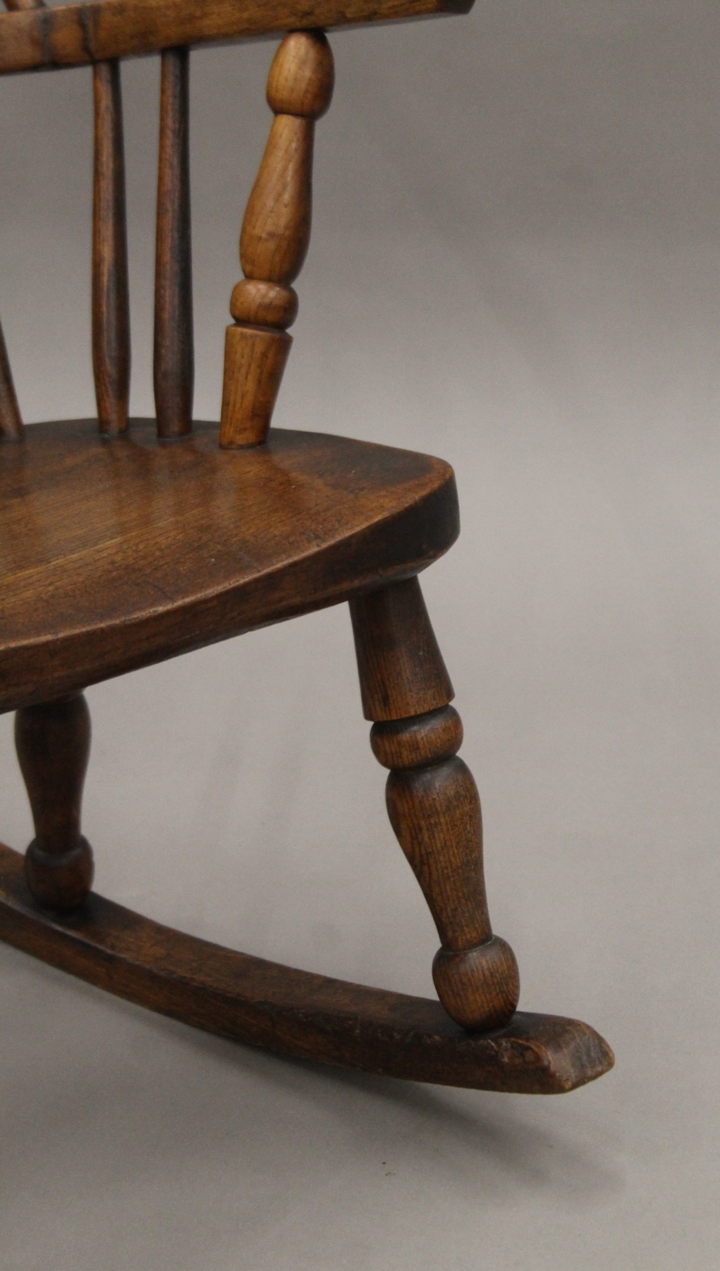 A Victorian elm child's stick back open arm rocking chair. - Image 4 of 4