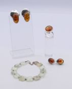 A silver and amber ring, two pairs of earrings and a jade bracelet. The latter 16 cm long.