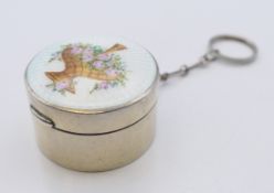 An early 20th century enamel decorated silver pill box. 4 cm diameter.