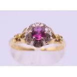 An 18 ct gold ruby and diamond cluster ring. Ring size N/O. 3.3 grammes total weight.
