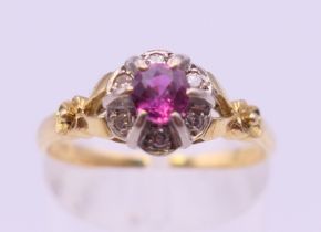 An 18 ct gold ruby and diamond cluster ring. Ring size N/O. 3.3 grammes total weight.