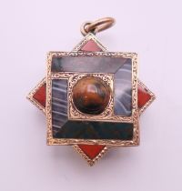 A Victorian Scottish hardstone pendant with glass back. 2.5 cm high.