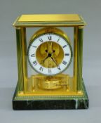 A Jaeger LeCoutre Atmos clock mounted on a green variegated marble plinth base. 24 cm high.