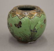 A small late 19th/early 20th century Japanese cloisonne vase decorated with butterflies amongst