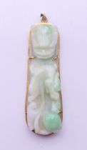 An 18 ct gold mounted Chinese jade belt hook formed as a pendant with gilt metal suspension loop.