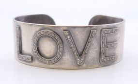 A silver and diamond Love bangle. 6 cm wide. 41.4 grammes total weight.