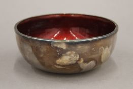 A beaten silver clad enamel bowl. 15.5 cm diameter.