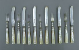 A set of six mother-of-pearl handled silver cake knives and forks. The knives 16 cm long. 272.