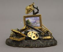 A 19th century Swiss gilt bronze and enamel sculpture, formed as various artists equipment,