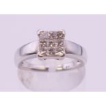 An unmarked 18 ct white gold square set nine stone diamond ring. Ring size L.