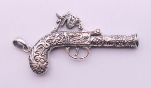 A sterling silver pendant formed as a gun. 6 cm high.