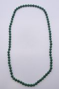 A string of malachite beads. 88 cm long.