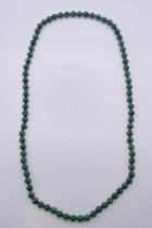 A string of malachite beads. 88 cm long.