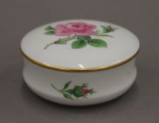 A Meissen porcelain trinket box decorated with roses. 7 cm diameter.
