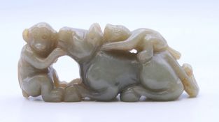 A jade carving of a lion and two monkeys. 8.5 cm long.