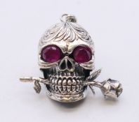 A skull and rose form pendant. 4.5 cm high.