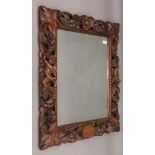A 19th century carved walnut wall mirror decorated with putti, flowers, fruit and scroll work.