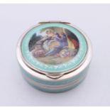 An early 20th century silver and enamel pill box, the lid decorated with a courting couple. 4.
