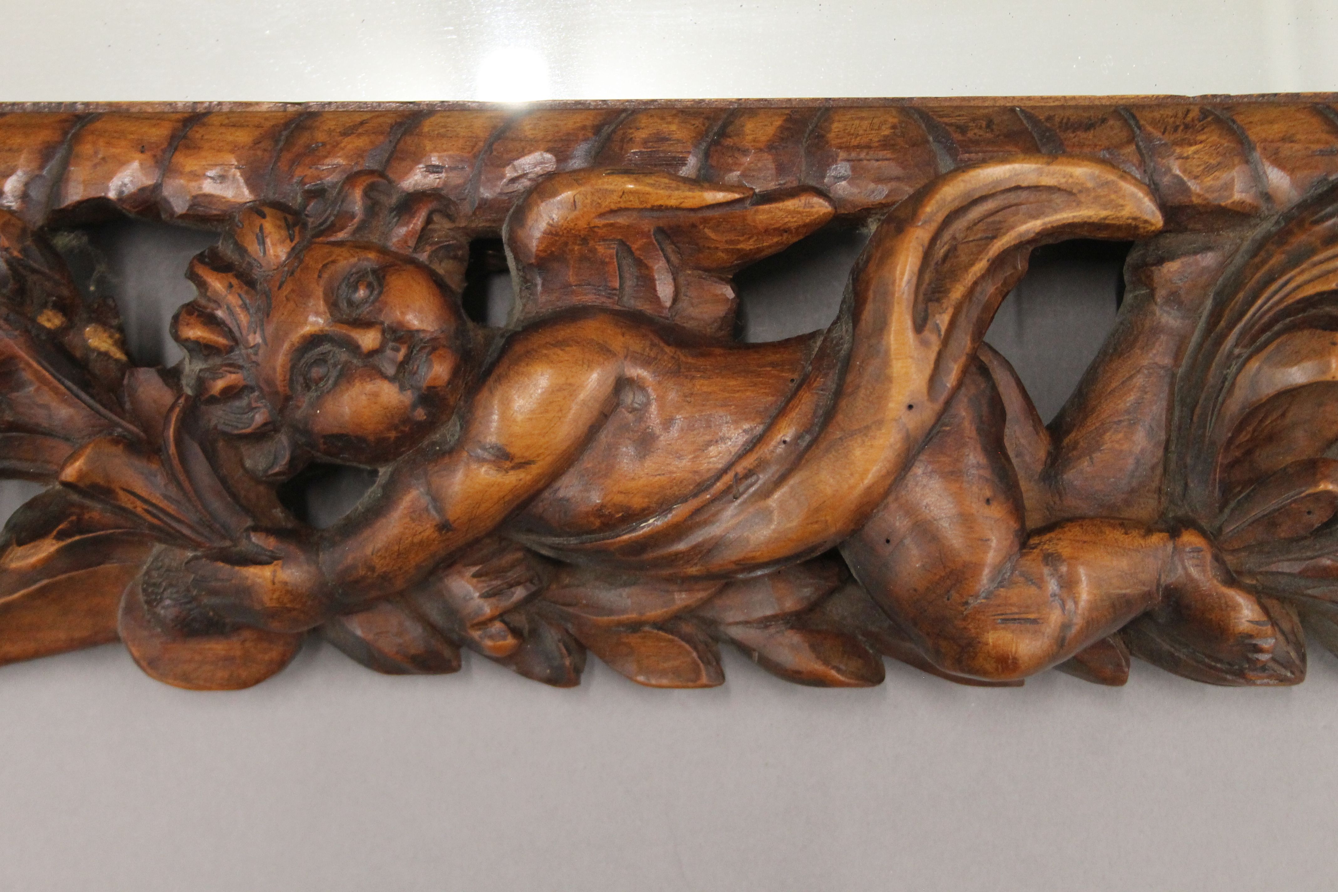 A 19th century carved walnut wall mirror decorated with putti, flowers, fruit and scroll work. - Image 3 of 3