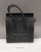 A black leather bag by Celine Paris, with outer cover. 30 cm wide.
