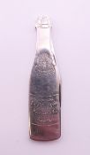 A novelty penknife formed as a champagne bottle. 6.5 cm high.