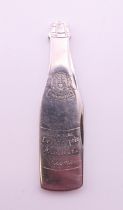 A novelty penknife formed as a champagne bottle. 6.5 cm high.