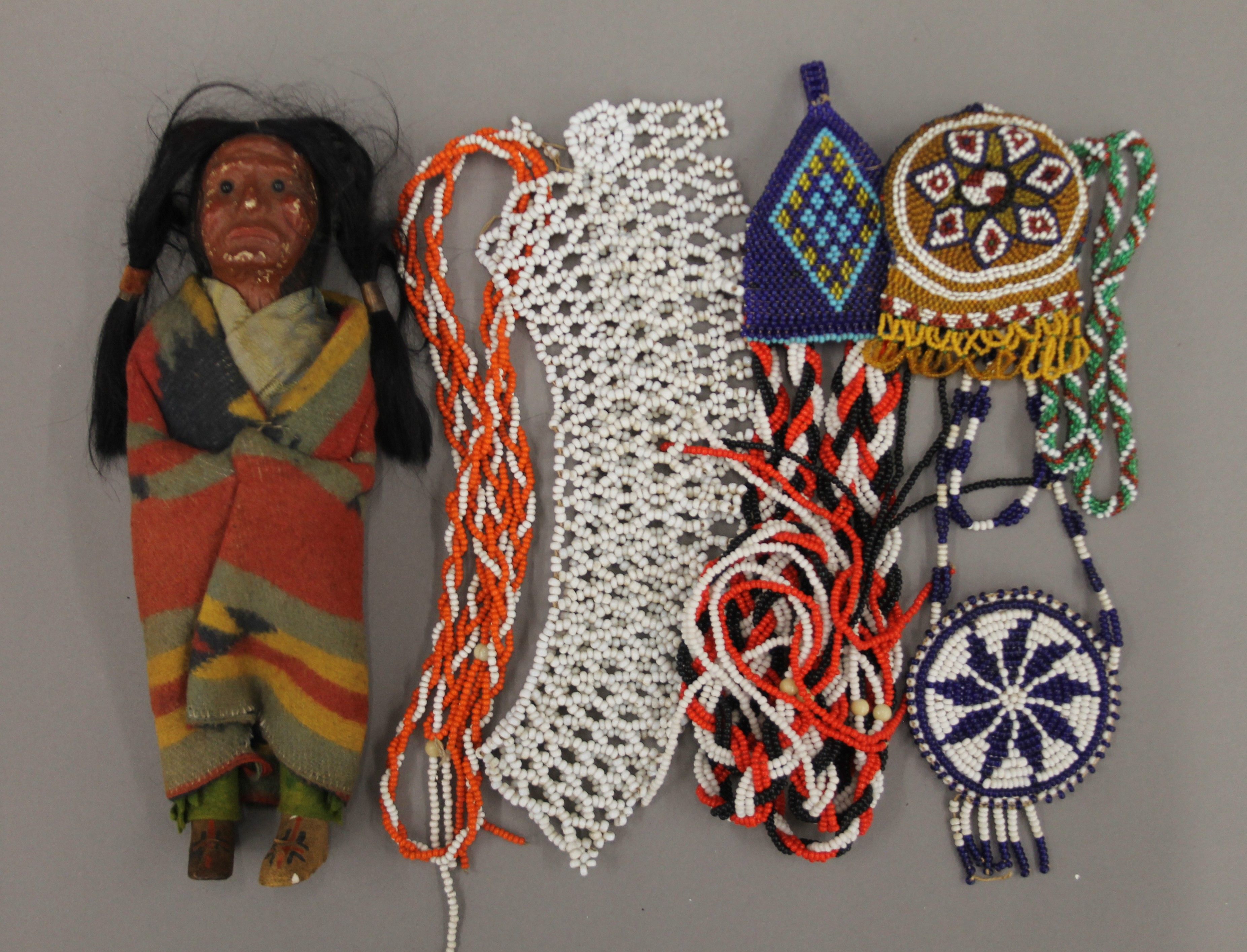 A Native American doll and a quantity of beadwork. The former 23 cm high.