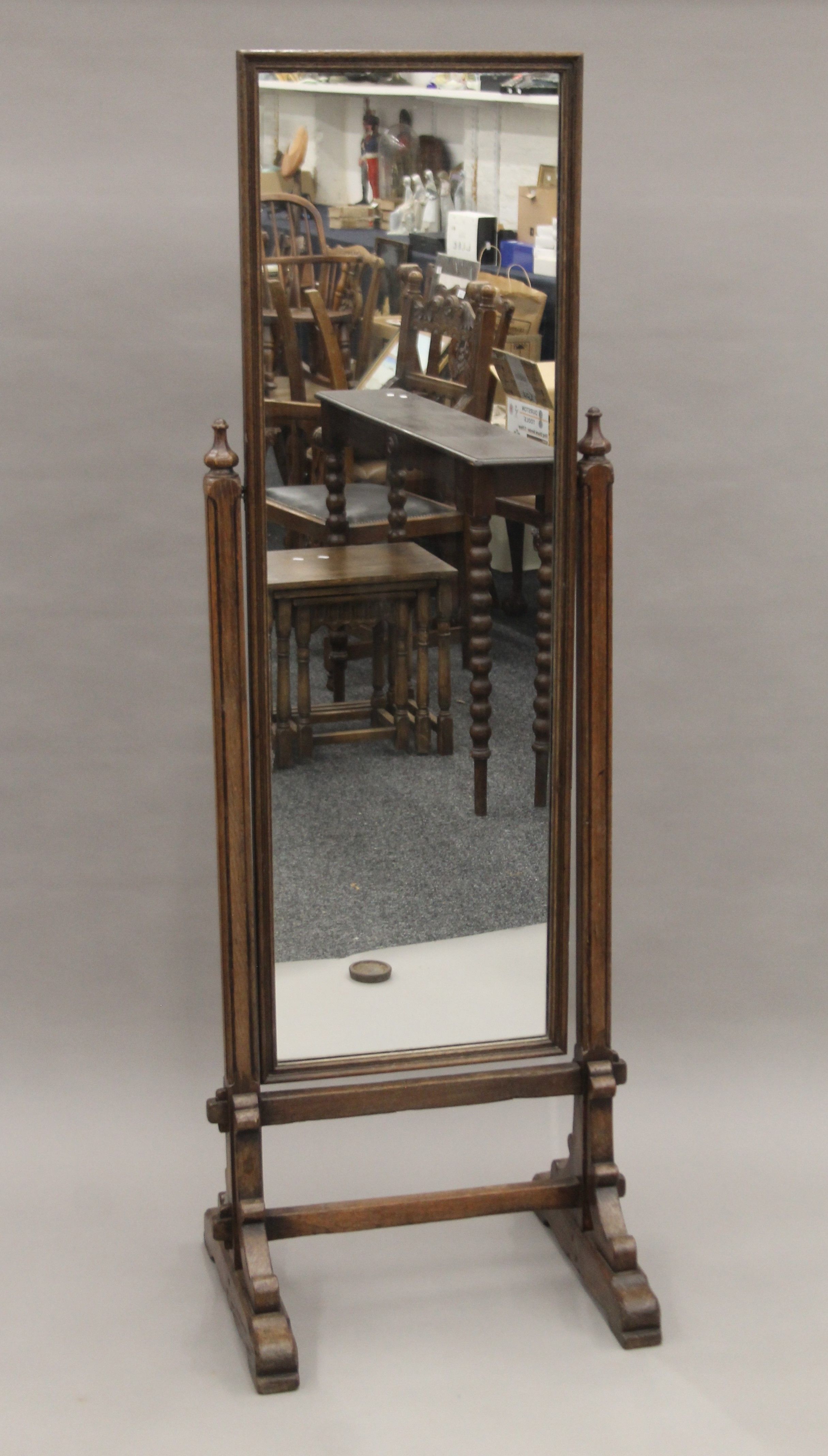 An early 20th century carved oak cheval mirror. 168.5 cm high.