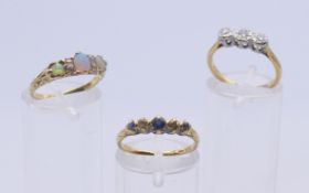 An 18 ct gold opal and diamond ring and two further diamond set 18 ct gold rings.