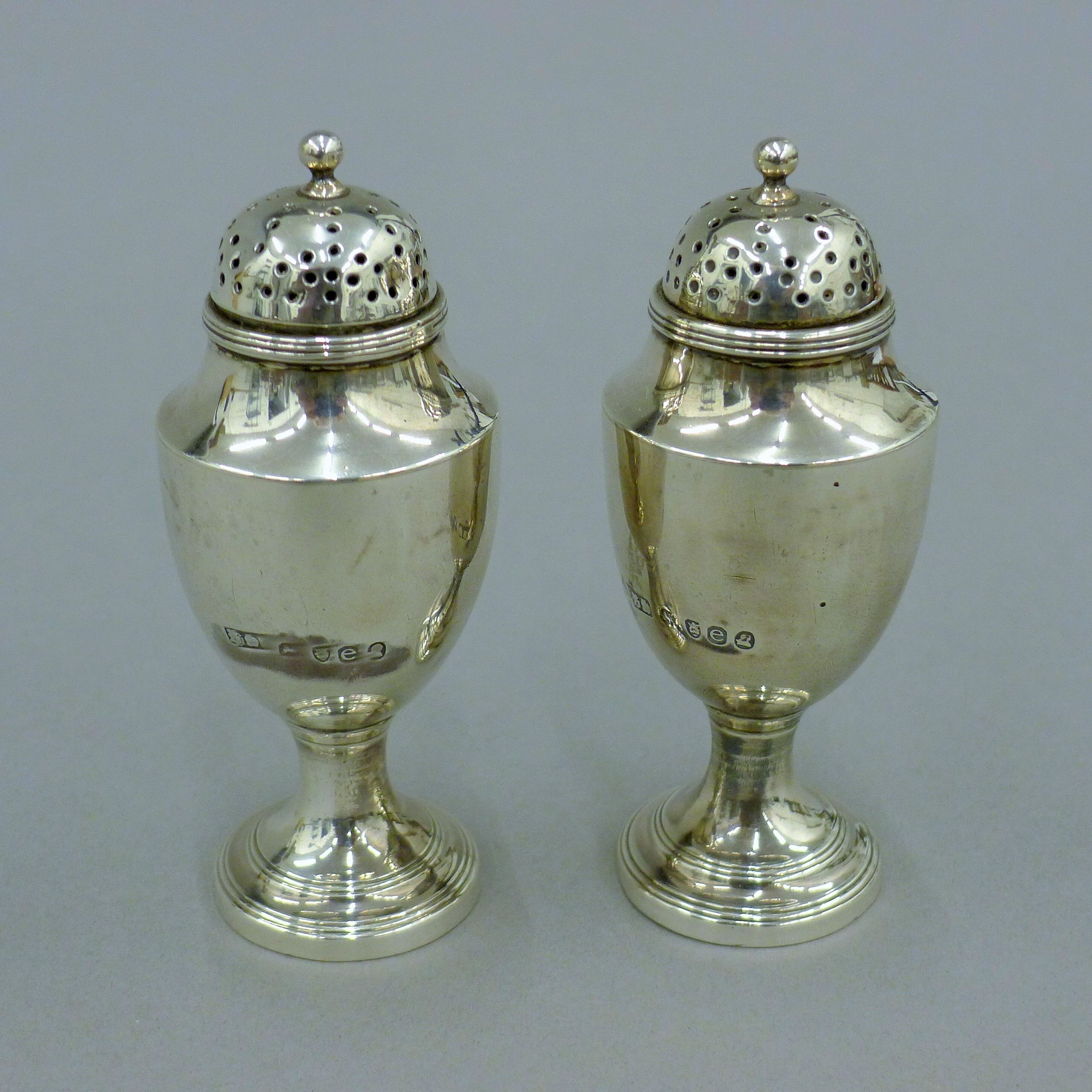 A pair of Georgian silver casters. 10 cm high. 141.8 grammes.