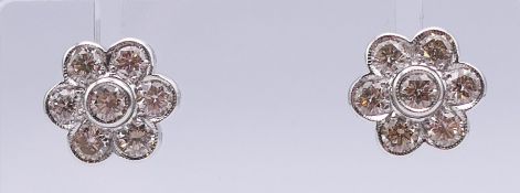 A pair of 18 ct white gold diamond earrings. 1.2 cm diameter. 4.6 grammes total weight.