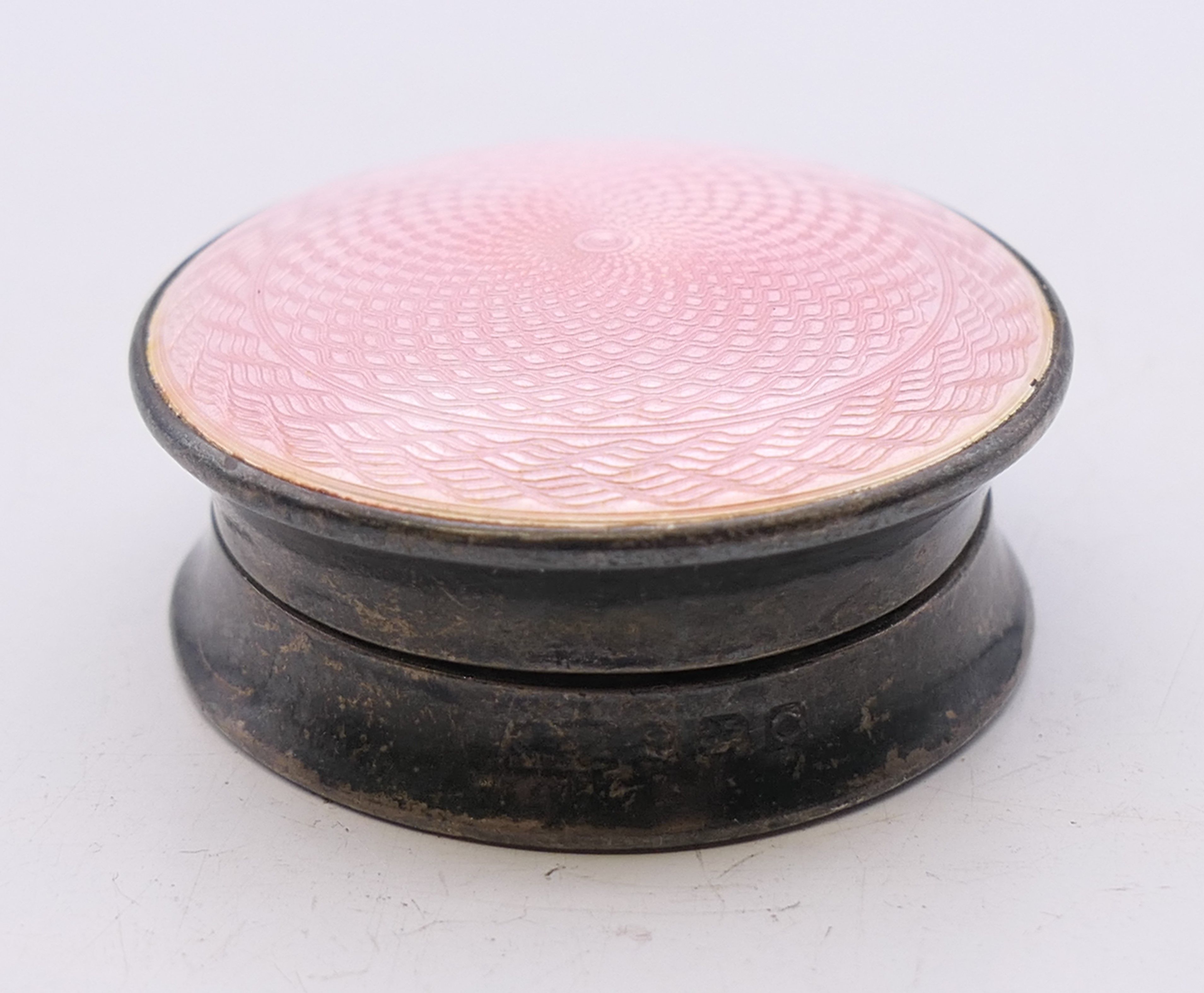 A silver and pink enamel balm pot. 3.75 cm diameter.