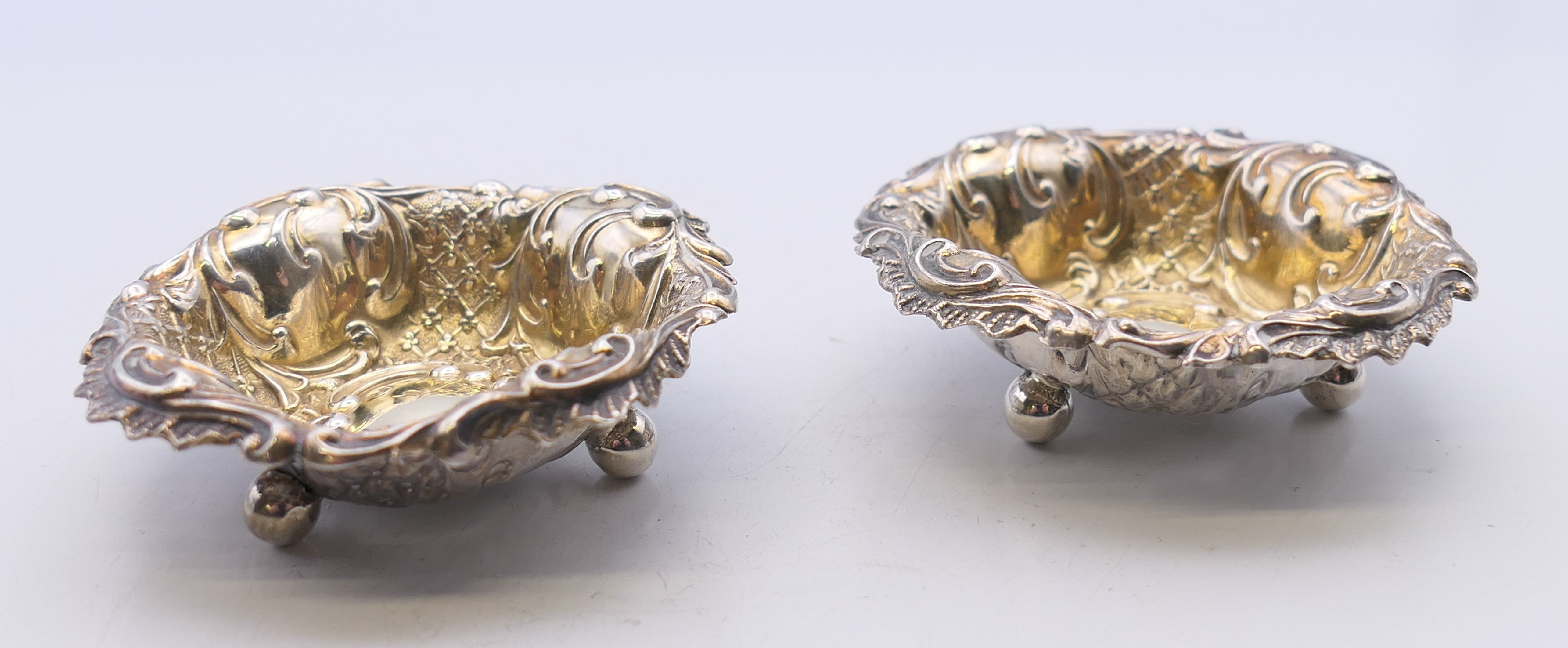 A pair of embossed silver gilt salts. 6 cm diameter. 25 grammes.