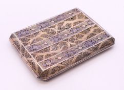 An unmarked white metal filigree cigarette case with enamel decoration. 10 cm wide. 100.