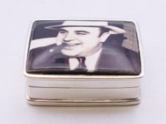 A silver Al Capone pill box. 3 cm wide.