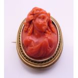 A 15 ct gold carved coral brooch. 3.25 cm high. 14.4 grammes total weight.