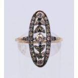 An unmarked 18 ct gold pierced scrolling diamond ring. Ring size O.