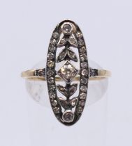 An unmarked 18 ct gold pierced scrolling diamond ring. Ring size O.