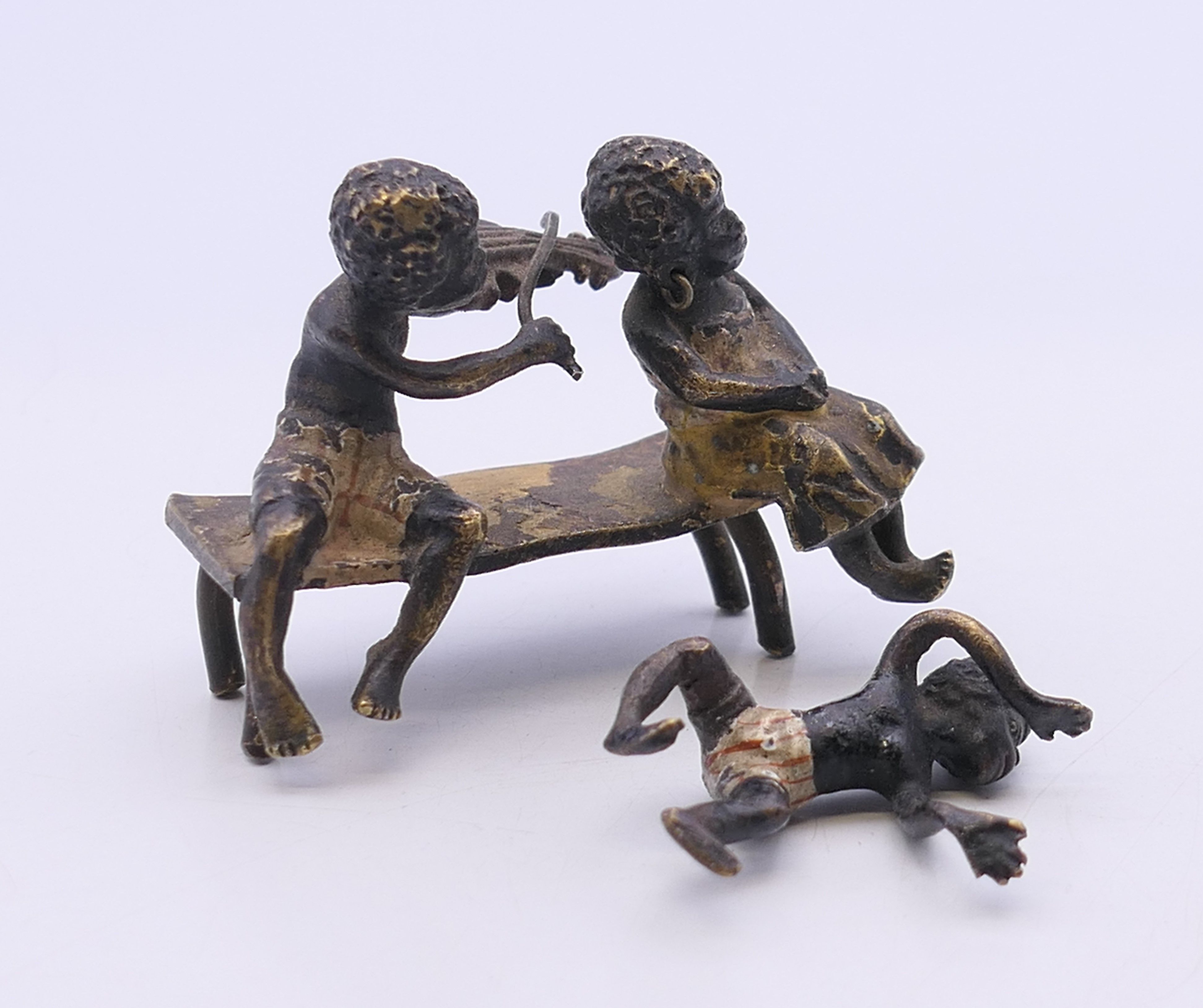 A 19th century Austrian cold painted bronze model formed as two figures seated on a bench,