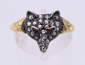 An unmarked gold diamond and ruby set fox mask ring. Ring size Q/R.